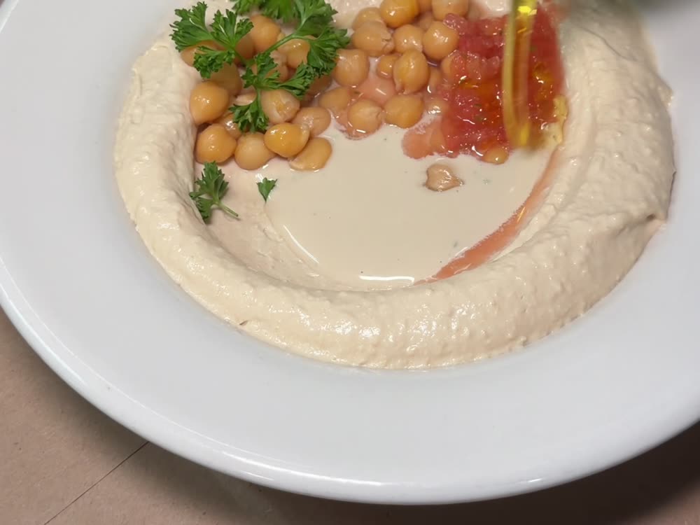 A plate of hummus topped with chickpeas and olive oil